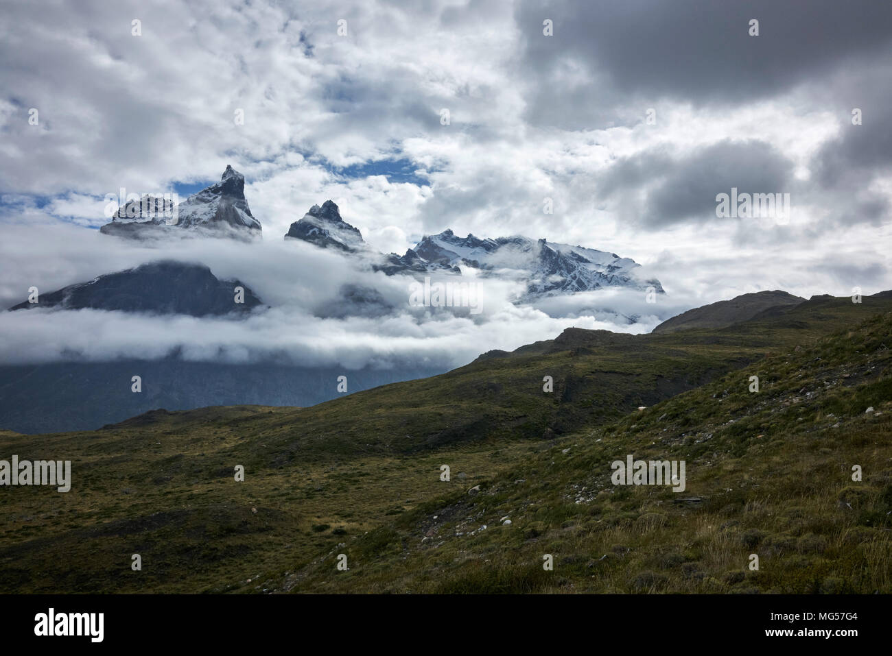 Cerro Paine Grande und Berge inmitten der Wolken. Panorama. Weite Einstellung. Stockfoto
