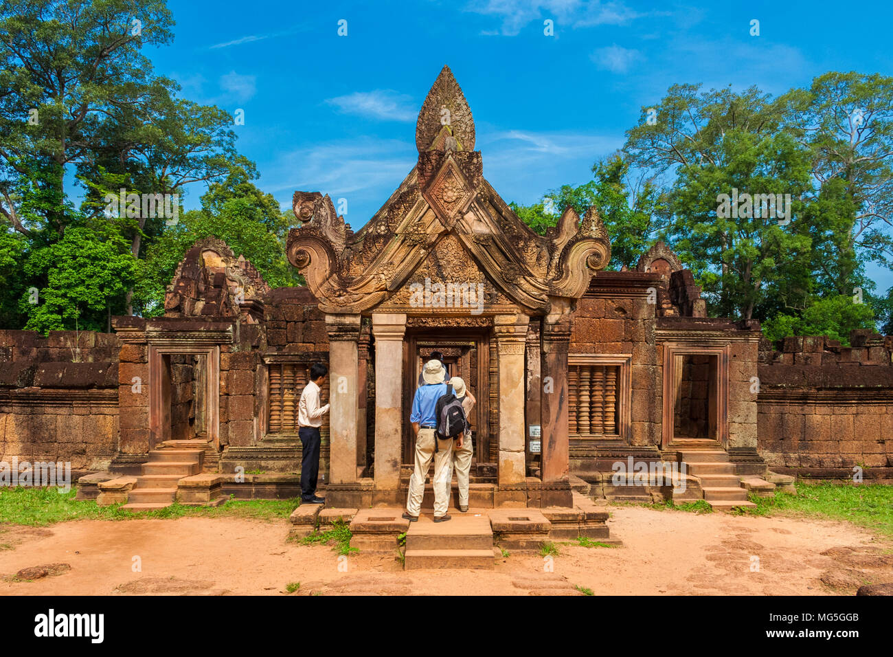 Touristen bewundern die East gopura des zweiten Gehäuse mit dem erstaunlichen geschnitzten Giebel aus rotem Sandstein in der Kambodschanischen Banteay Srei Tempel. Stockfoto