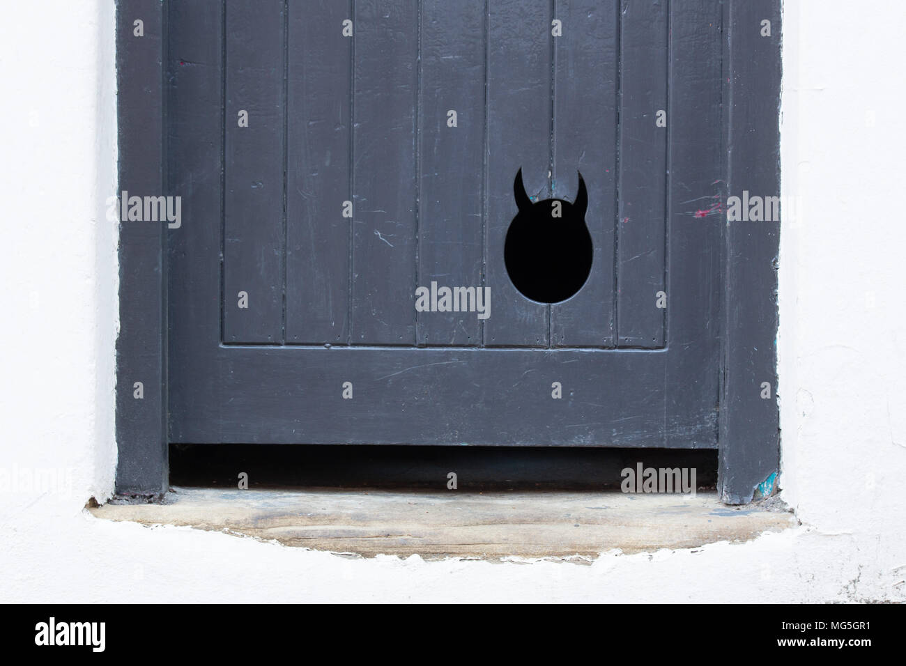 Eine ungewöhnliche Katzenklappe in eine Tür zu einer Eigenschaft auf steilen Hügel, Lincoln, Großbritannien. Viele Touristen und diese Tür, ohne zu erkennen, was es ist. Stockfoto