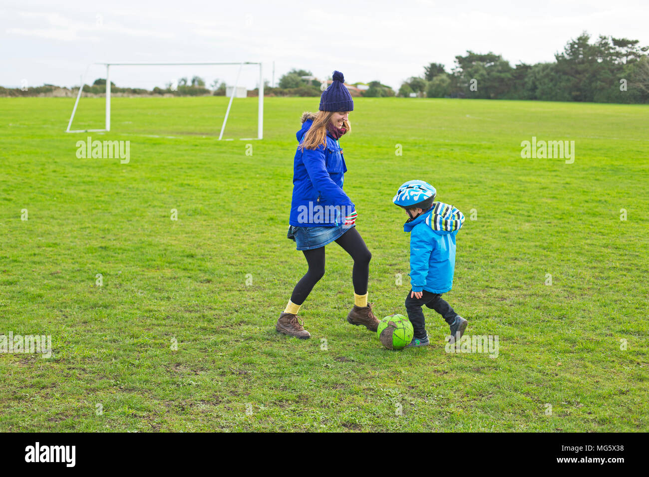 Eine Mutter mit ihrem Sohn Fußball spielen Stockfoto