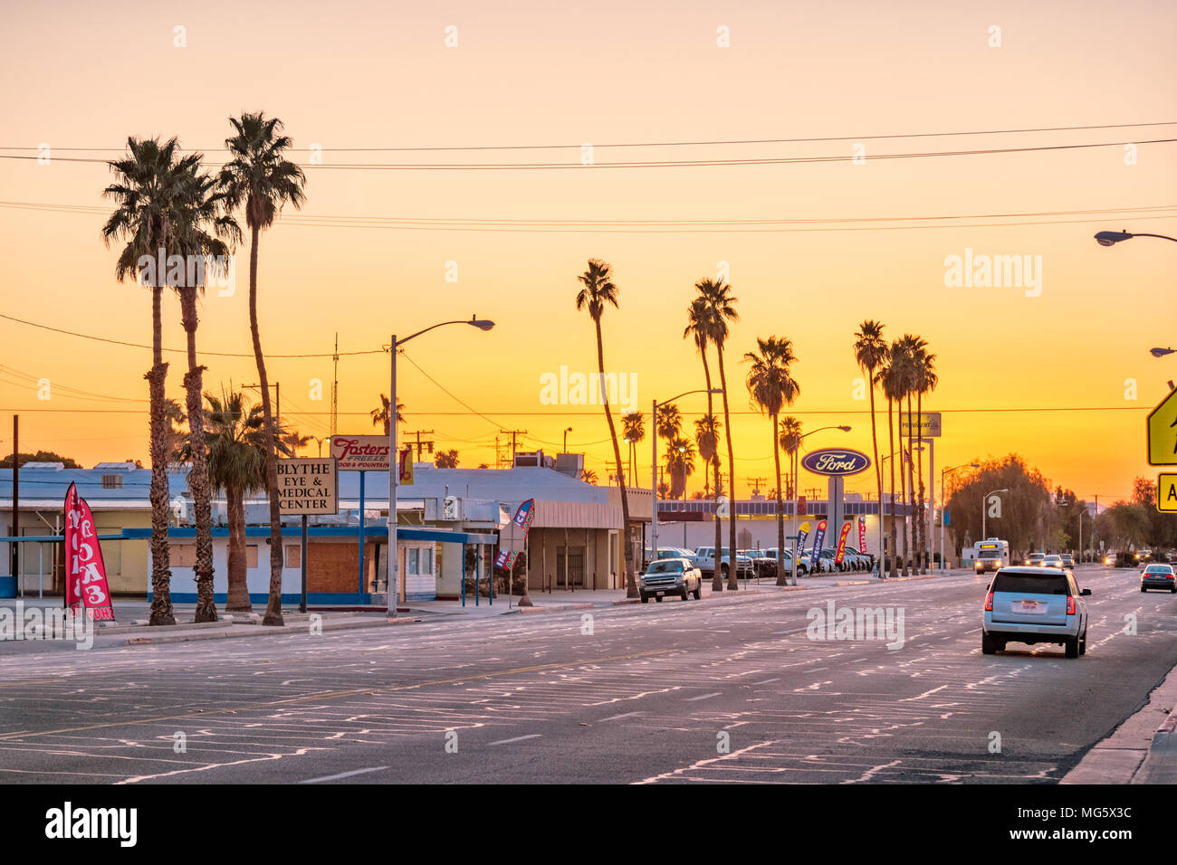 Hobsonway, einer Hauptstraße mit Palmen in Blythe, Riverside County, Kalifornien, USA bei Sonnenuntergang Stockfoto