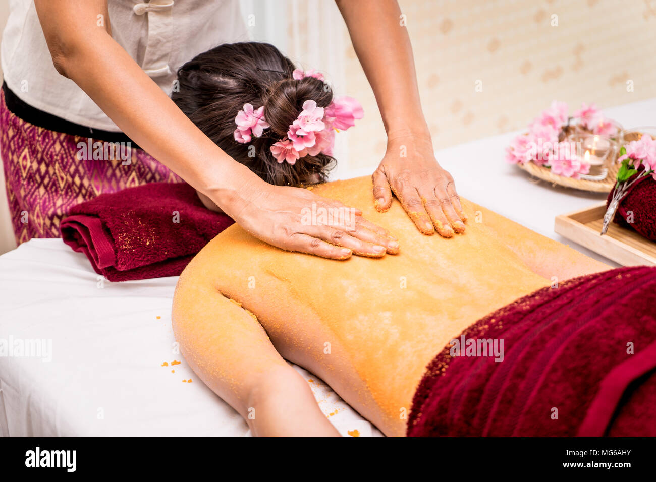 Frau ist wieder Haut Peeling mit orange Salz in Thai Spa Stockfoto