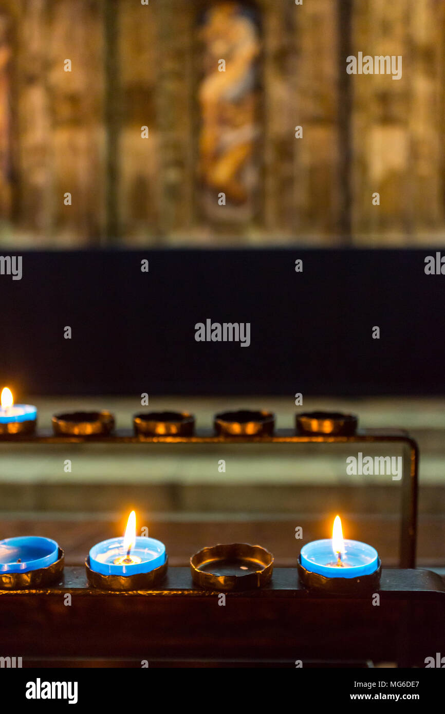 Gloucester, Großbritannien - 28 März 2015: Kerzen von Anbetern hell brennen in einem abgedunkelten Raum in der Kathedrale von Gloucester. Stockfoto
