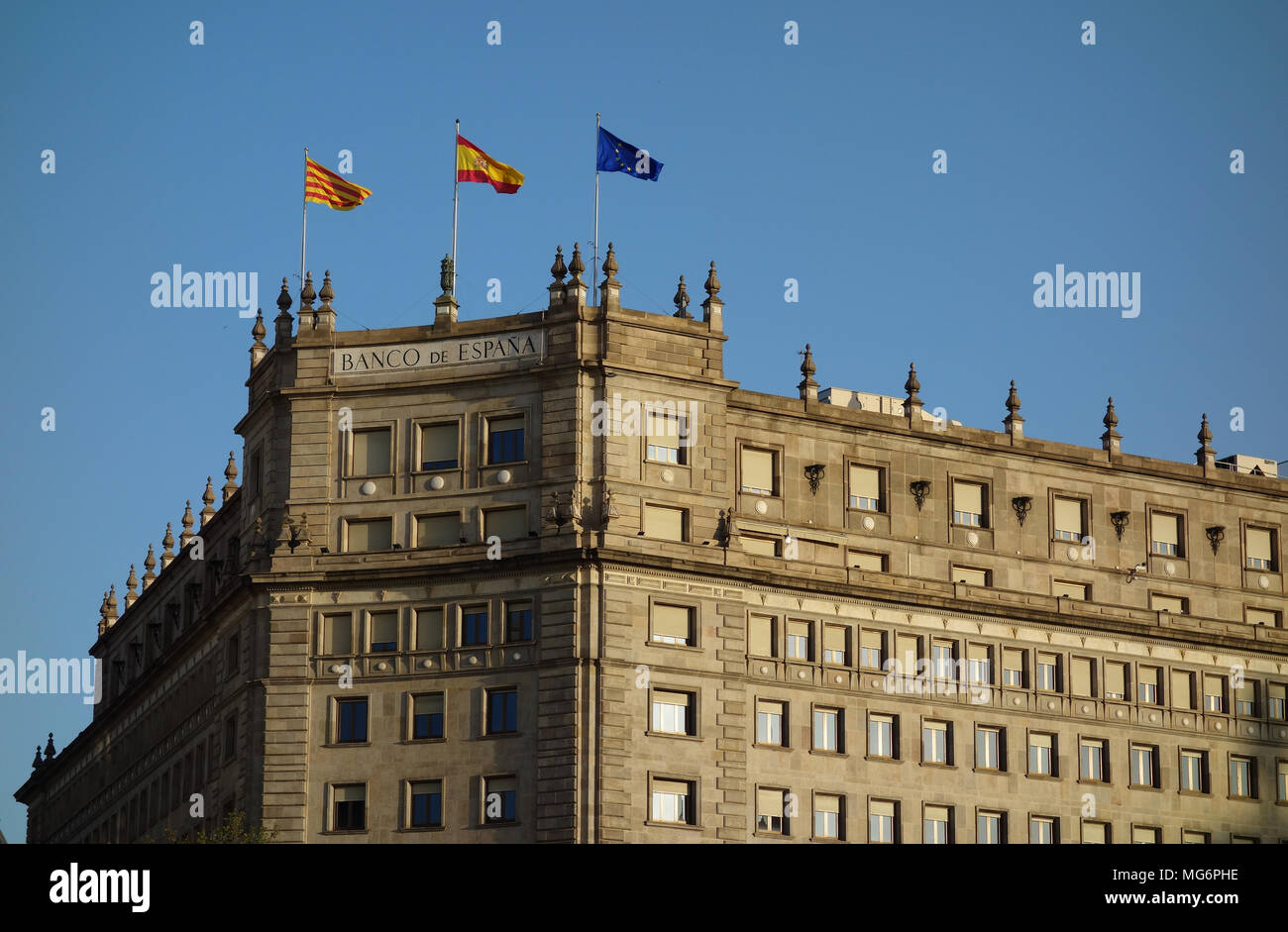 Katalanisch, Spanisch und EU-Flaggen auf Banco de España Gebäude an der Plaza Catalunia, Barcelona Stockfoto