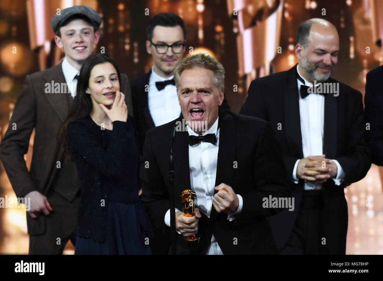 27 April 2018, Deutschland, Berlin: 68. Deutscher Filmpreis, die LOLA, Award, Zeremonie, Award Show: Produzent Thomas Blieninger (C) steht auf der Bühne bei der Preisverleihung. Blieninger wurde mit der Lola in der Kategorie "Beste Kinder "Film" für den Film "Die fabelhafte Welt der Amelie rennt" (Berg Wunder · Eine unerwartete Freundschaft). Foto: Gregor Fischer/dpa Stockfoto