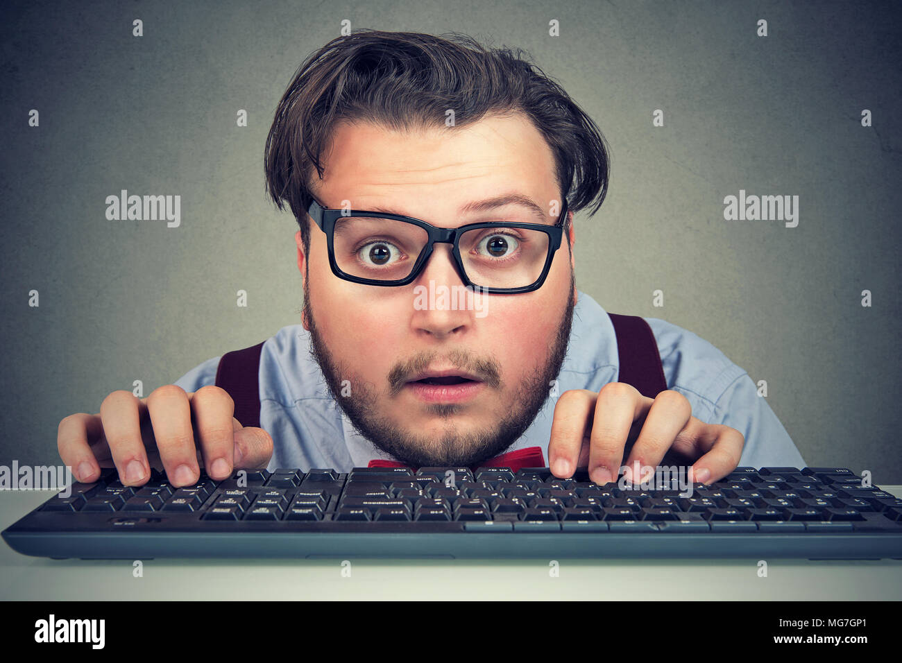 Überrascht Geschäftsmann Eingabe über Tastatur schauen erstaunt Stockfoto
