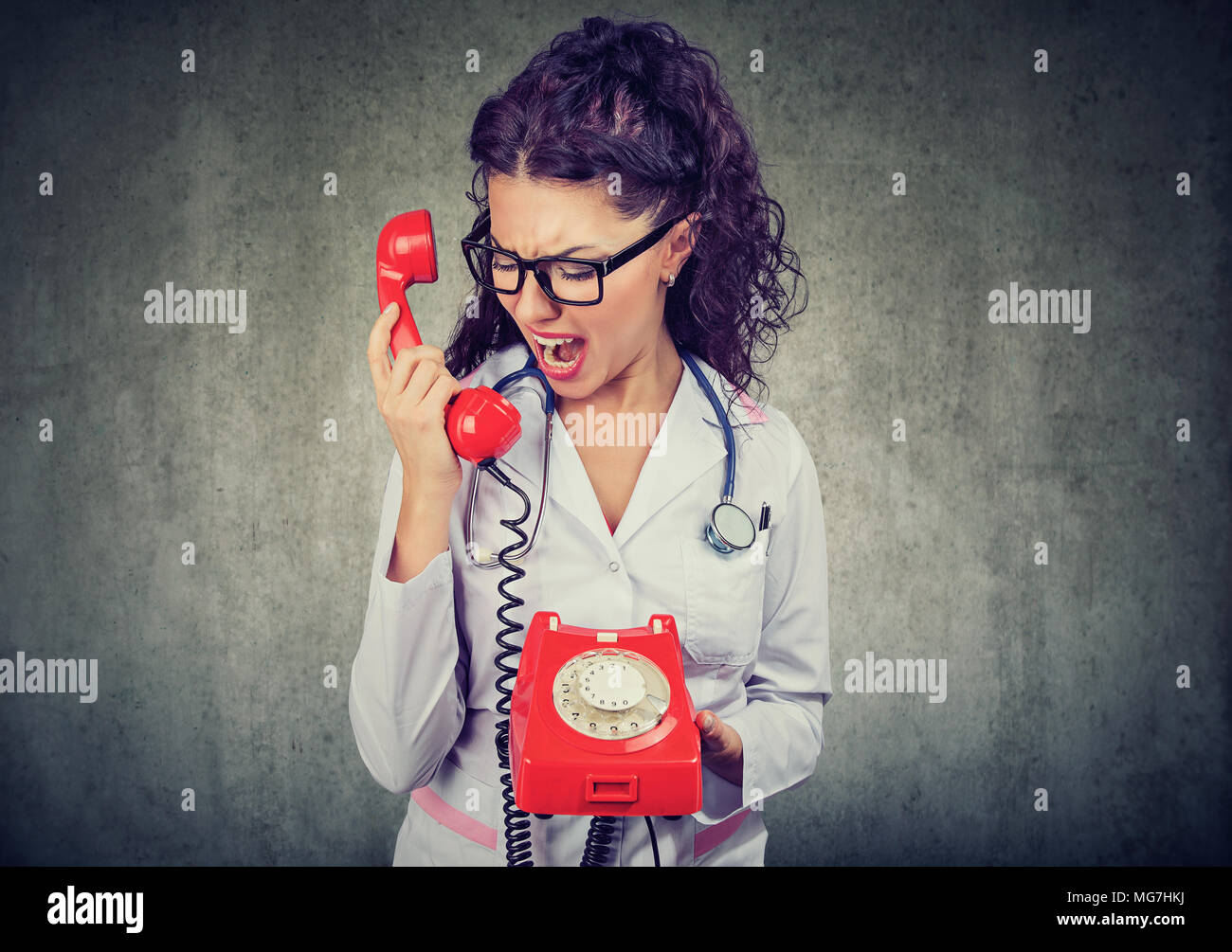 Wütende junge Arzt schreiend auf dem Telefon Stockfoto