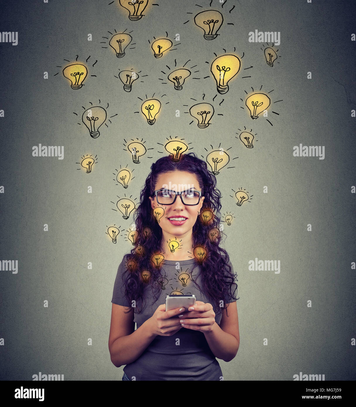 Junge Frau in Brillen holding Smartphone hat viele erfolgreiche Ideen. Stockfoto