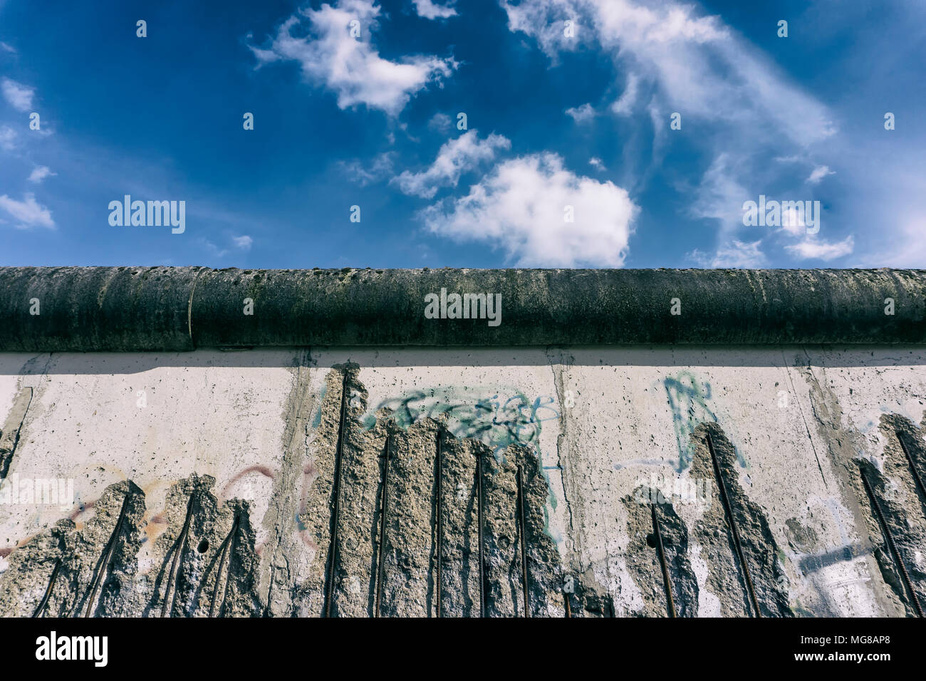 Ein Teil der Berliner Mauer an der Gedenkstätte Berliner Mauer Park mit Himmel und Wolken Stockfoto