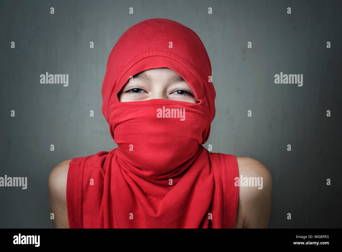 Studio Portrait eines lächelnden Jungen tragen ein Kopftuch. Die junge Band  eine T-Shirt wie ein hijab Stockfotografie - Alamy