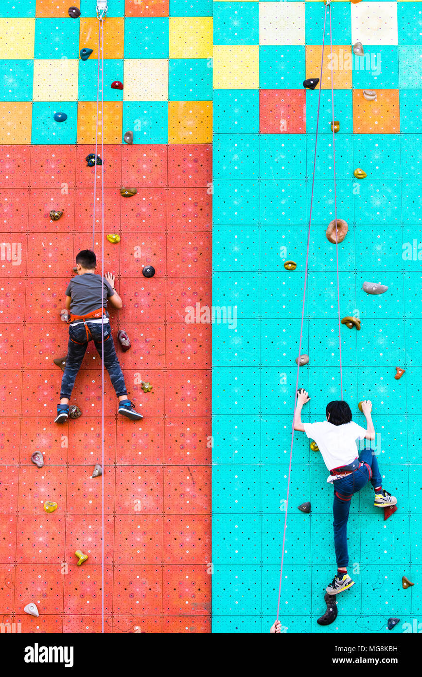 Rom, Italien, 25. April 2018. Zwei Jungen klettern in künstlichen Mauer Freizeitaktivitäten Aktivität während der Tag der Erde sport Platz in outdoor Park Stockfoto