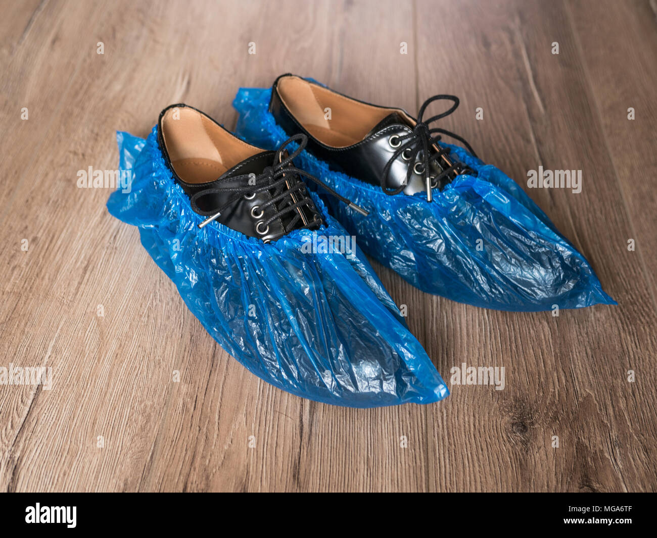 Blau medizinische Überziehschuhe sind abgenutzt über Schuhe auf dem Fußboden, leath Stockfoto