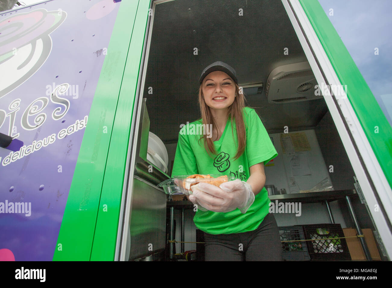 Portrait von jugendlich Sommer Mitarbeiter innerhalb einer Essen Lkw mit einem Container frittierte Speisen Stockfoto
