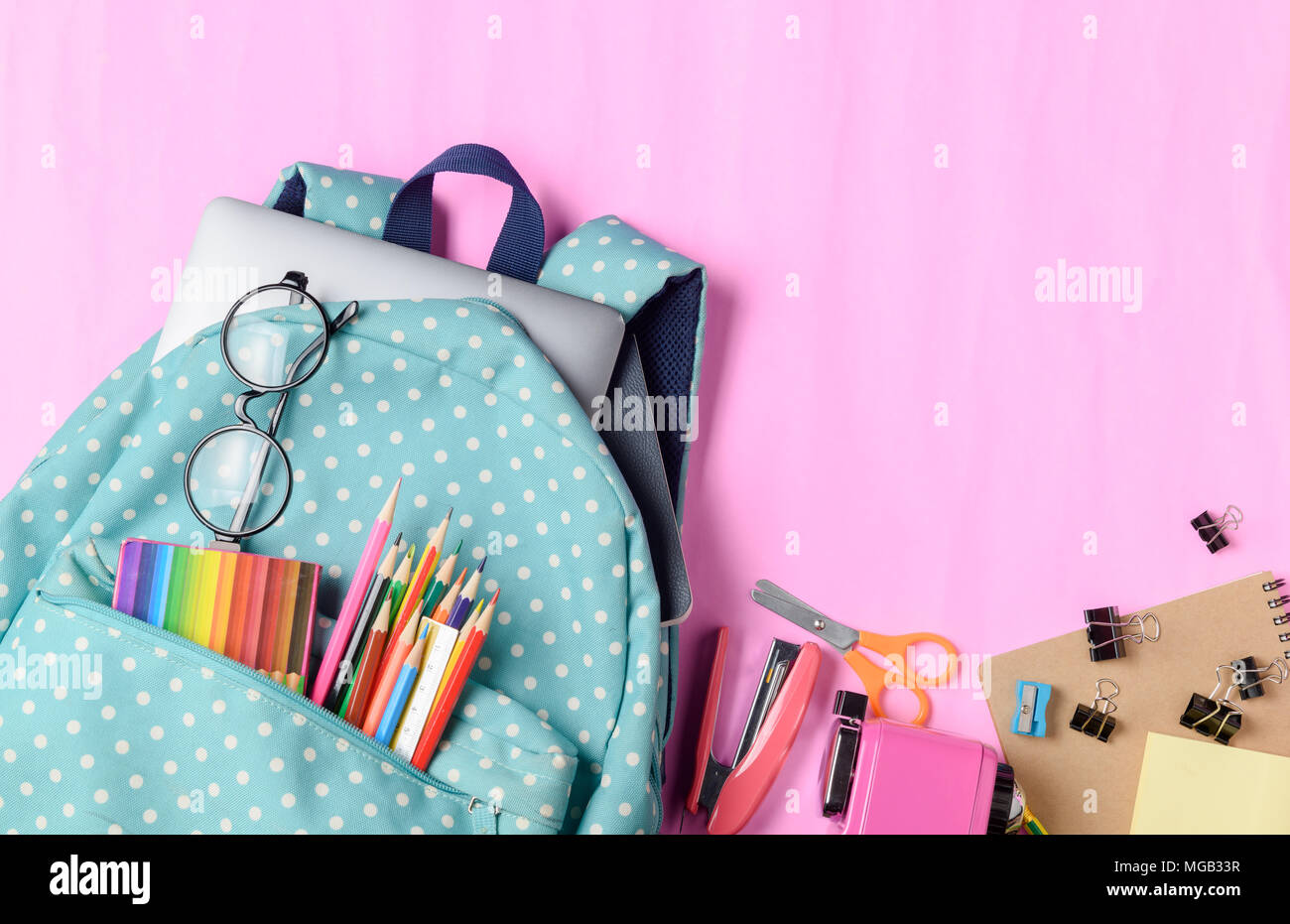Schule Rucksack mit Buntstift und Schulmaterial auf rosa Papier Hintergrund. Zurück zum Konzept der Schule. Stockfoto