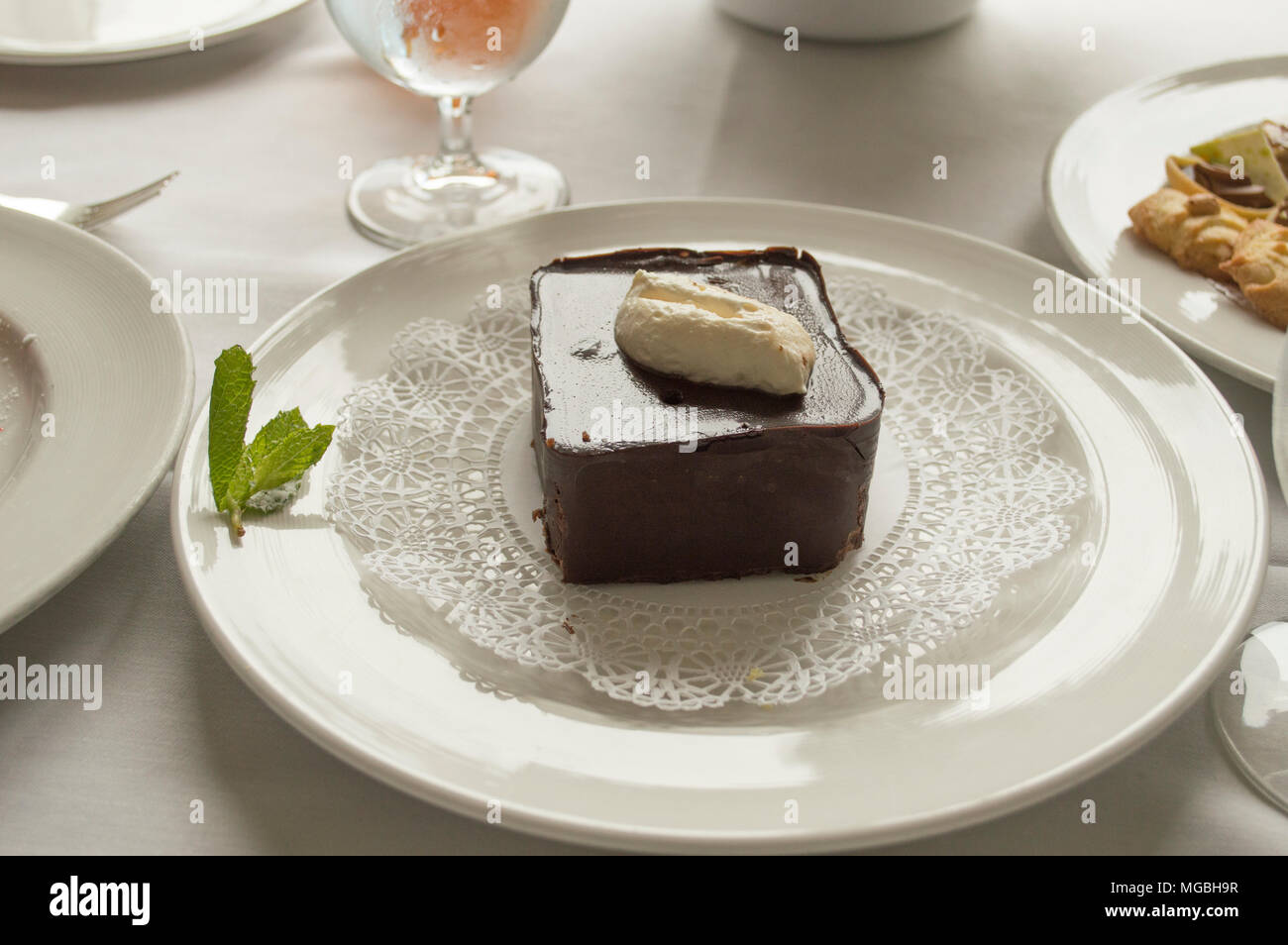 Das Stück ein Mousse au chocolat Torte auf einem ausgefallenen Platte gekrönt mit frischer Schlagsahne Stockfoto