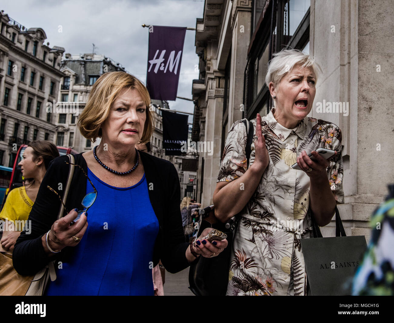 Zwei Frauen zu Fuß entlang der Straße, in Eile, mit erschrocken Ausdrücke, London, England, Großbritannien Stockfoto