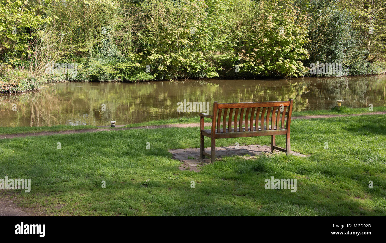 Eine leere Holzbank am Kanal gebaut für Leute, die Ruhe und die Szene inpeace und ruhigen bewundern. Stockfoto