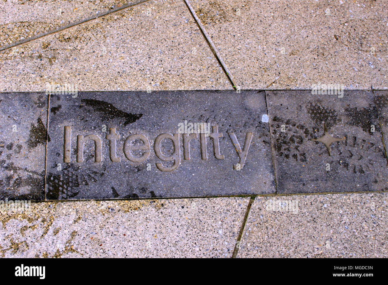 Das Wort Integrität in einen Pflasterstein mit sichtbaren Spuren einstellen Stockfoto