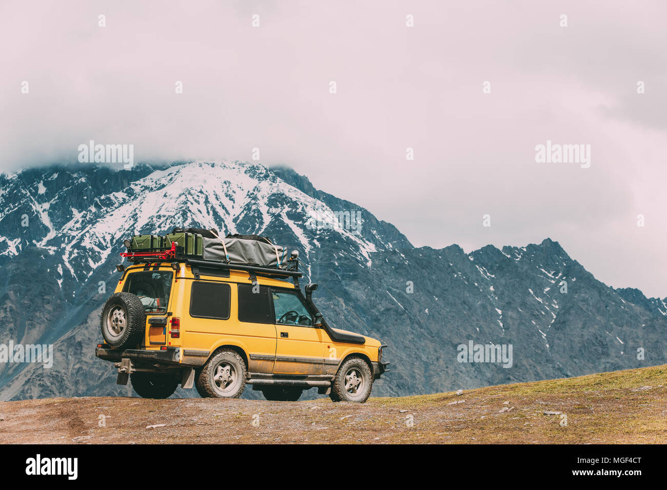 Gelbe SUV Auto auf Off-Road In Spring Mountains Landschaft In Georgien. Antrieb und Reisekonzept. Landschaft der Schlucht im Frühling. Stockfoto