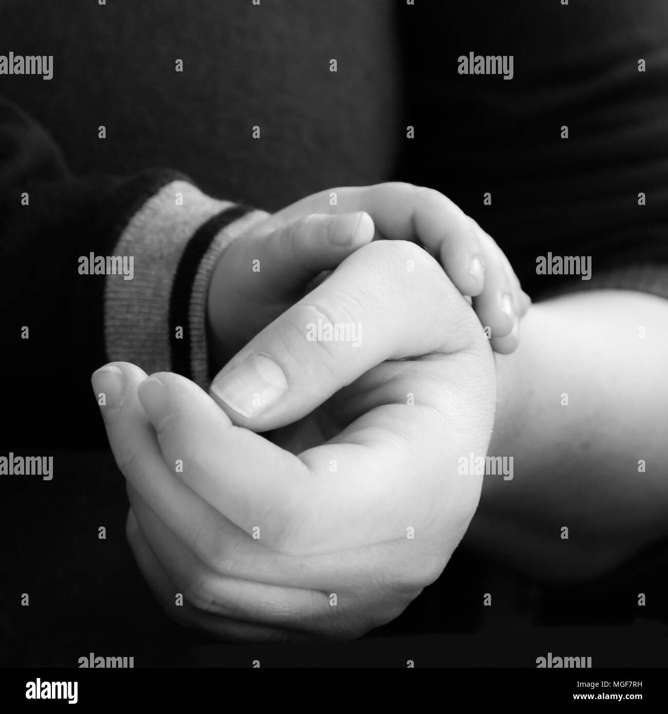 Kind die Hand seiner Mutter hält. Konzept von Reinheit und Liebe. Stockfoto