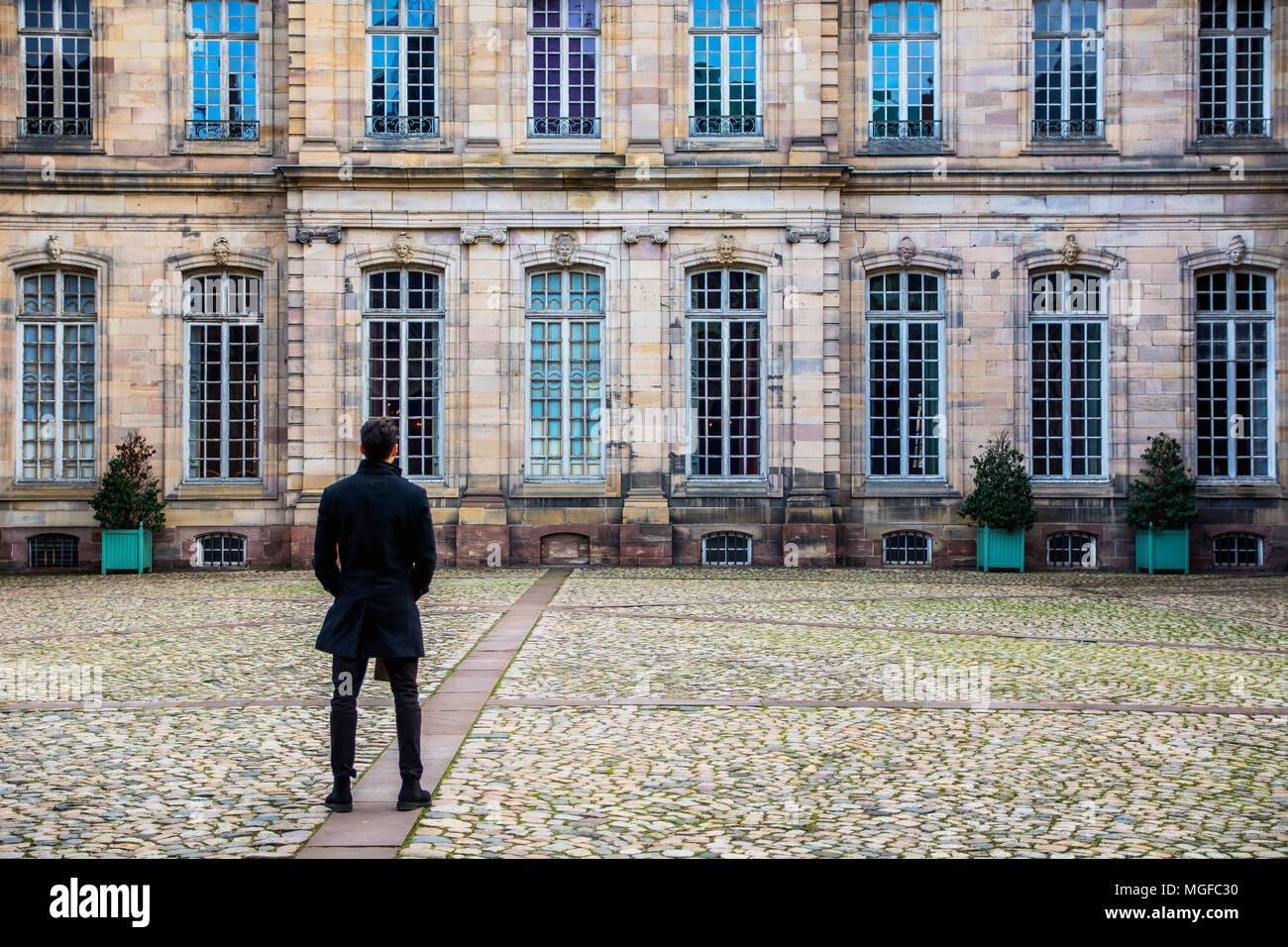Junger Mann am historischen Gebäude in Straßburg, Frankreich Stockfoto