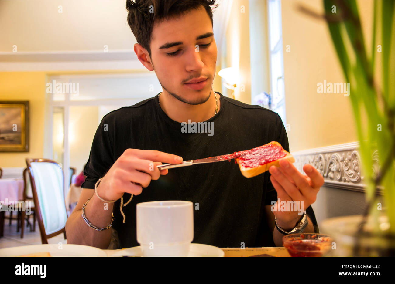 Attraktive junge Mann Essen Frühstück Stockfoto
