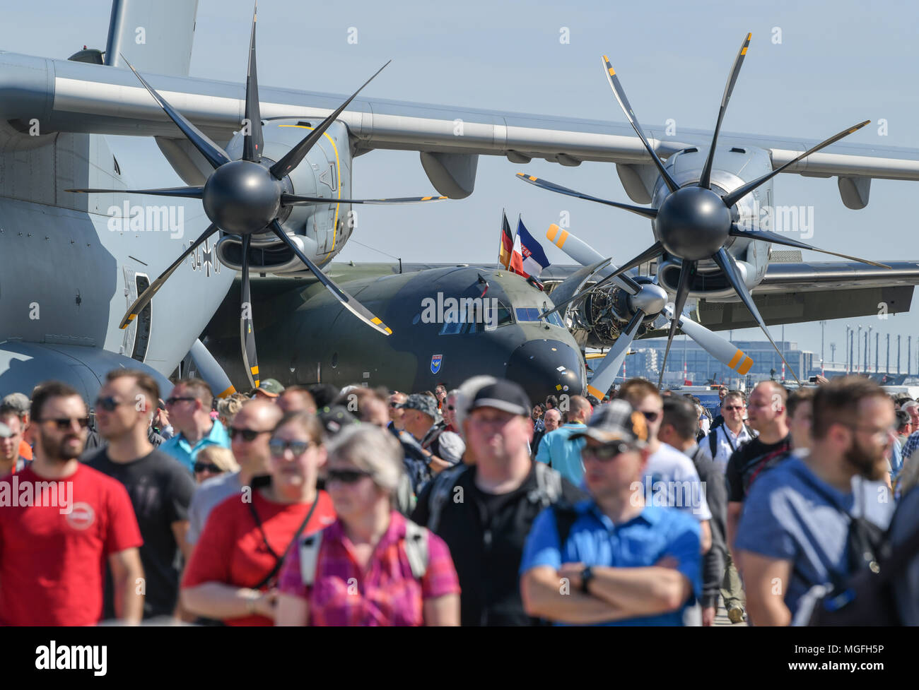 28 April 2018, Deutschland, Schönefeld: Viele Besucher zu Fuß durch das Gelände der ILA 2018. Die Propeller der Bundeswehr Transportflugzeug Airbus A400M im Vordergrund gesehen werden, während eine Transall C-160D im Hintergrund gesehen werden kann. Über 200 Flugzeuge werden während der ILA internationale Luftfahrt Ausstellung 2018 präsentiert. Die Veranstalter erwarten rund 150.000 Besucher. Die ILA findet zwischen 25. und 29. April 2018. Foto: Patrick Pleul/dpa-Zentralbild/dpa Stockfoto