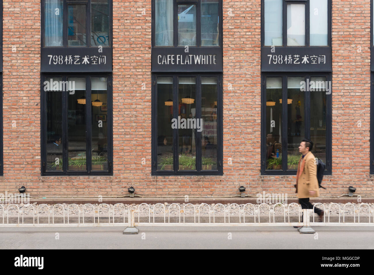 Man Walking pass ein Cafe an 798 Art Zone in Peking Stockfoto
