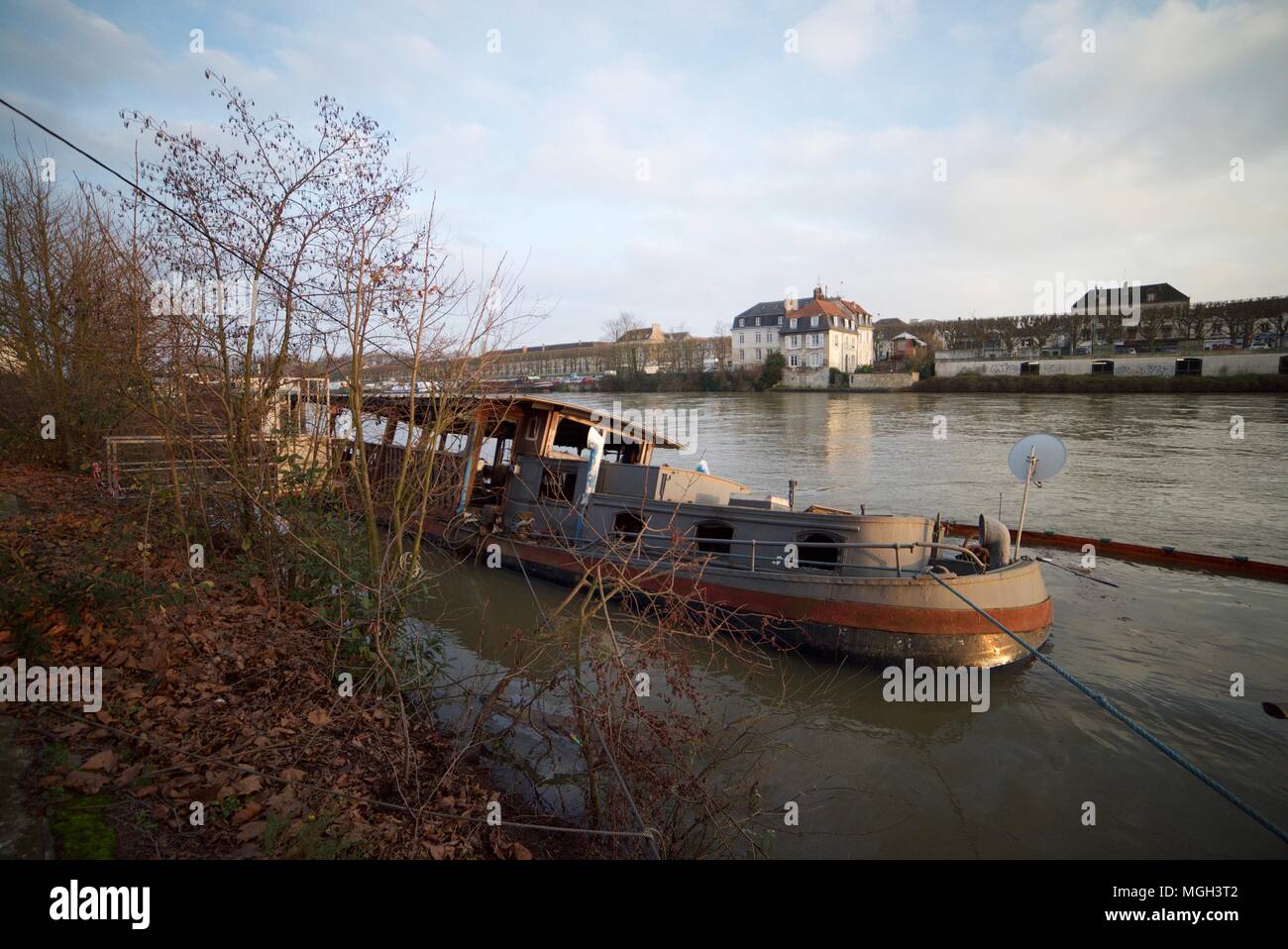 Eine kleine verlassene Boot aus Holz saß verfallenden und Kenterte am Fluss Stockfoto