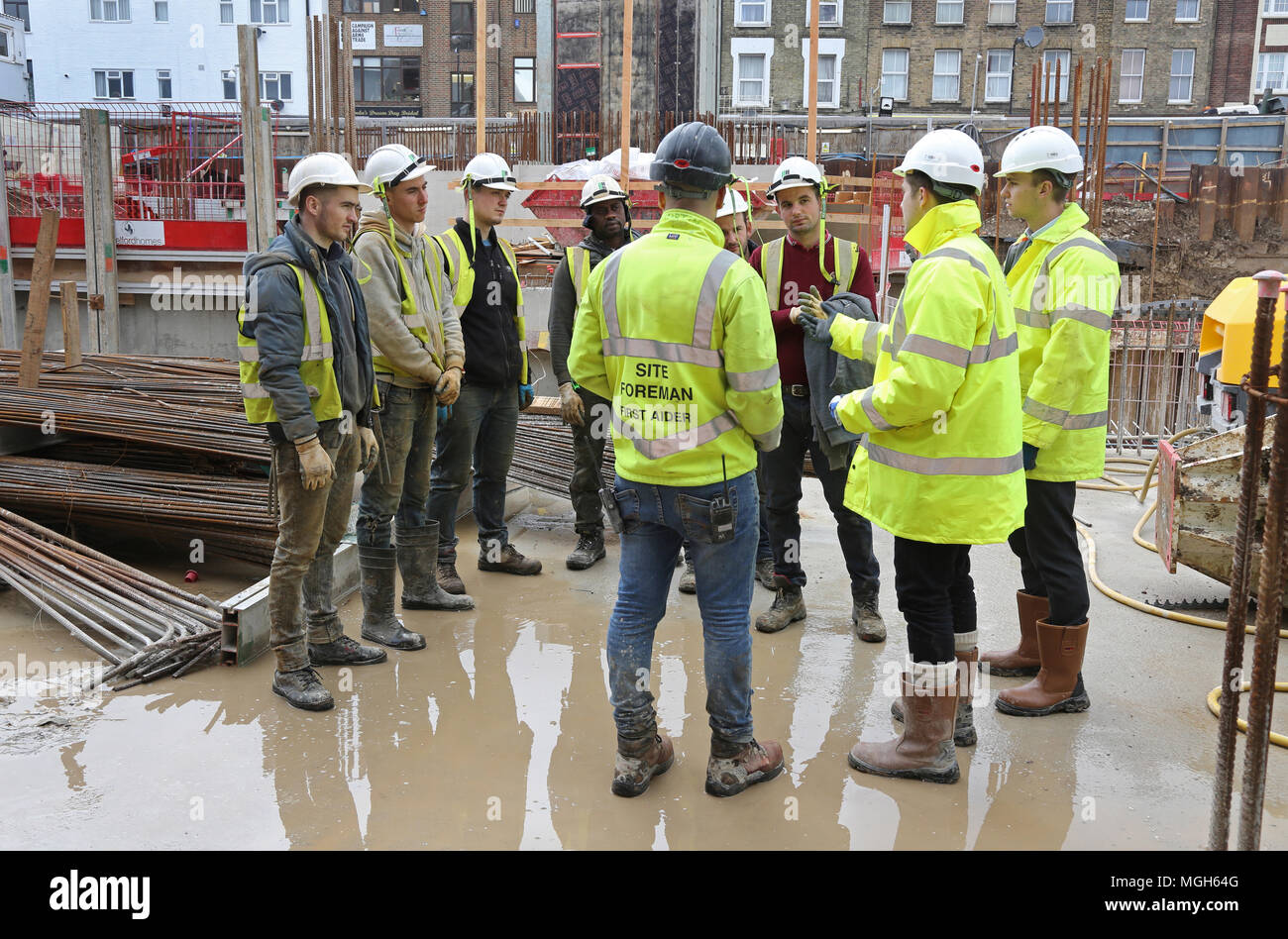 Ein "Toolbox Talk" findet auf einer Londoner Baustelle statt. Die Mitarbeiter am Standort erhalten Schulungen und Projektinformationen vom leitenden Projektmanagementteam Stockfoto