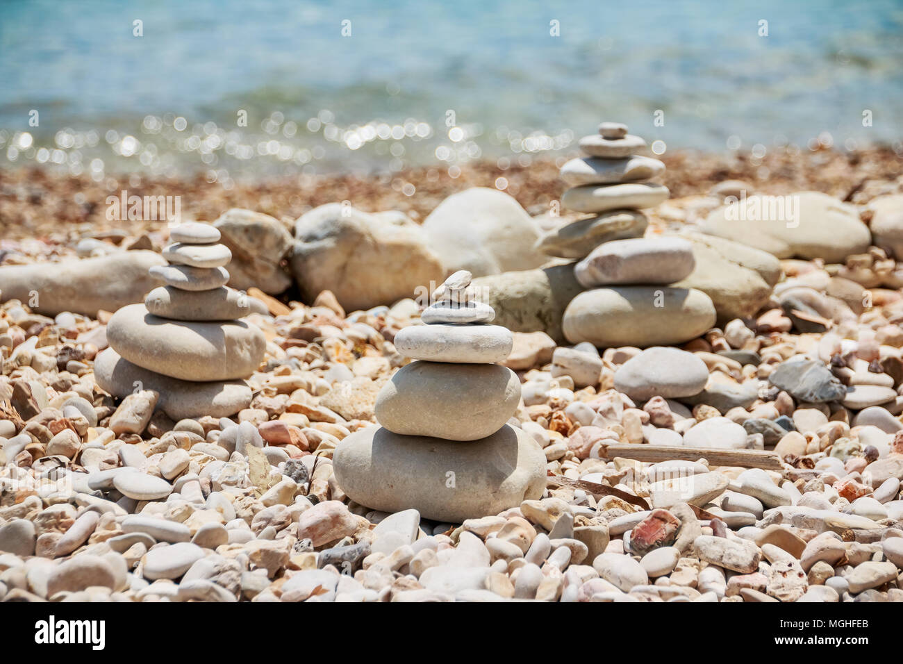 Stapel Steine am meer sommer Strand. Der Haufen der Kieselsteine auf dem steinigen Küste. Steine Pyramide auf Pebble Beach symbolisiert Stabilität, Zen, Harmonie, Balance. Tropische Meer Strand. Ferienhäuser Konzept Stockfoto