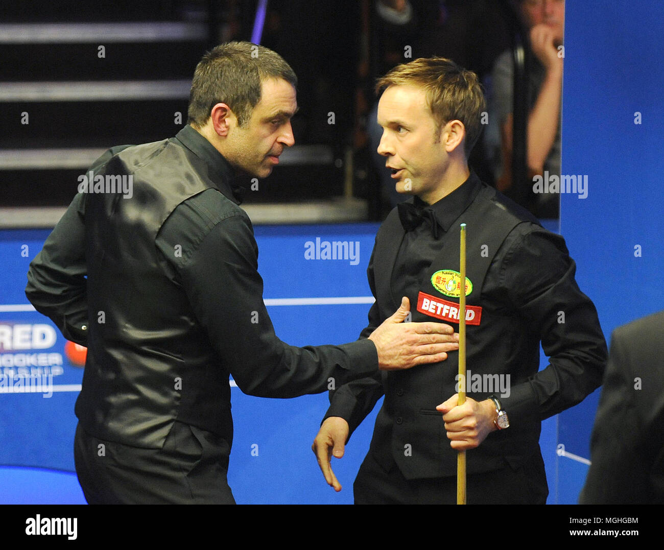 Ali Carter (rechts) schüttelt Hände mit Ronnie O' Sullivan nach ihm schlagen 13-9 während der Tag acht der 2018 Betfred Weltmeisterschaft an den Tiegel, Sheffield. Stockfoto