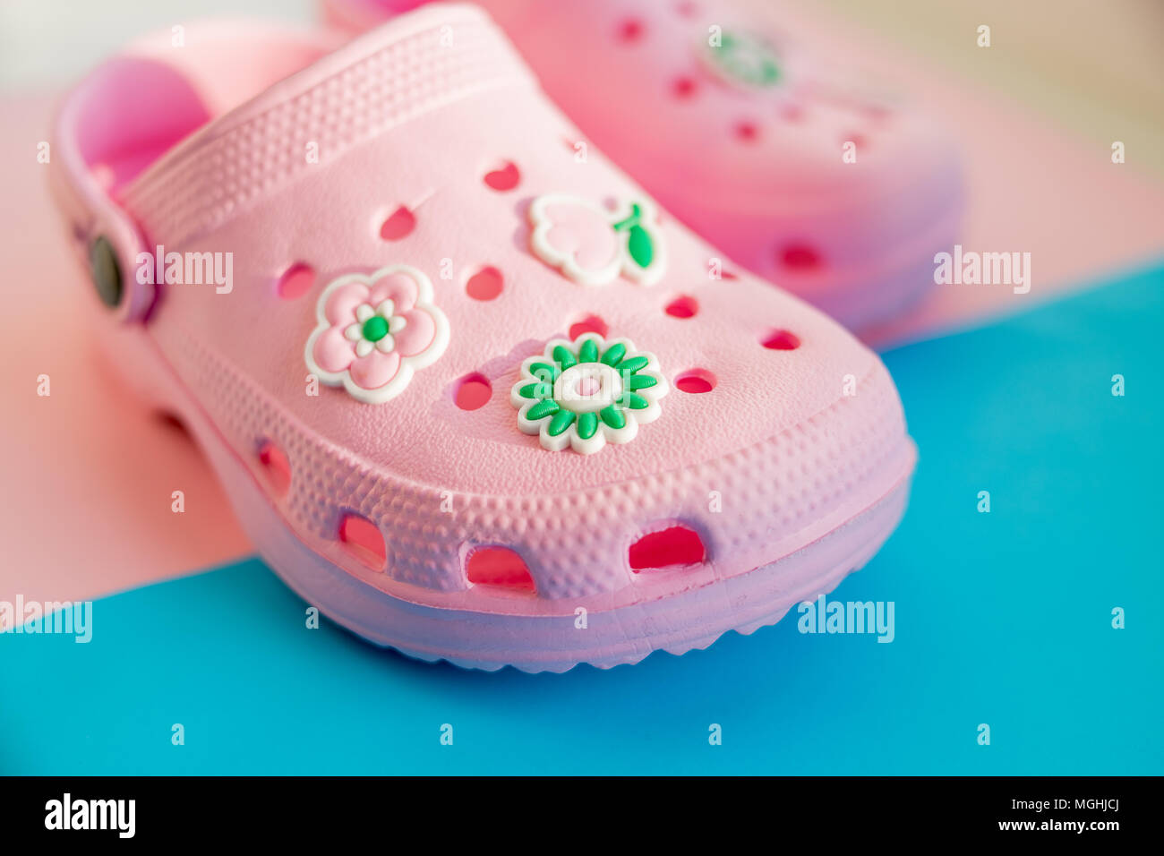Bunte Kinder Gummisandalen auf dem blauen Hintergrund isoliert. rosa gummi  Schuhe Kinderschuhe Stockfotografie - Alamy