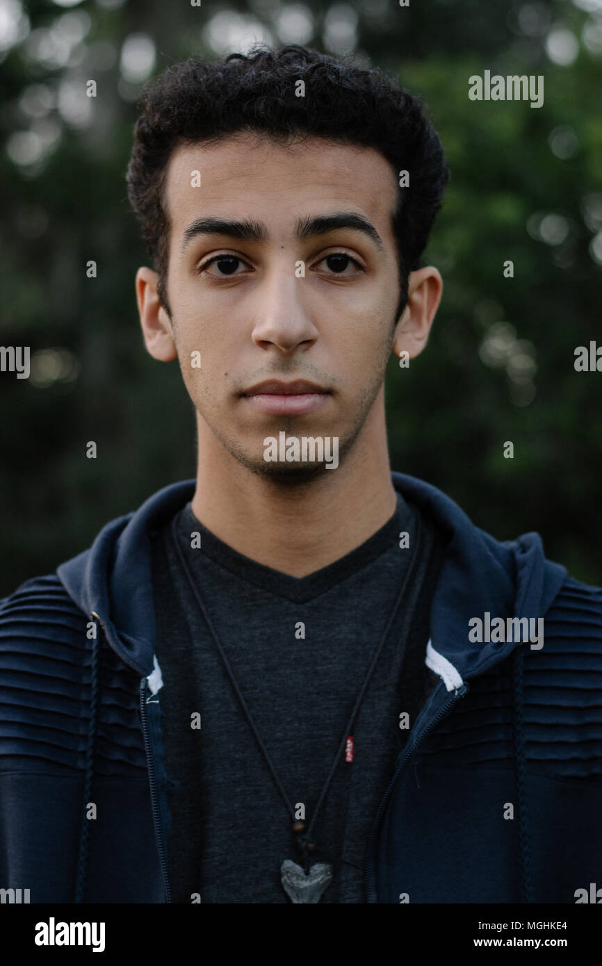 Junge moderne Trendy modische nahen östlichen Indischen männliches Modell Lachen und posiert in der Natur im Park für Portrait Kopf Schüsse Stockfoto