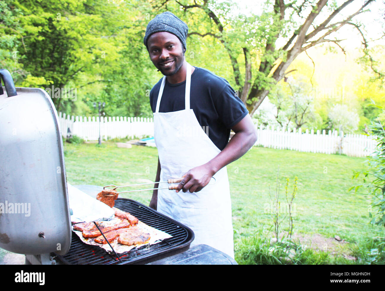 Ein fröhlicher Mann Grills im Freien im Park Stockfoto