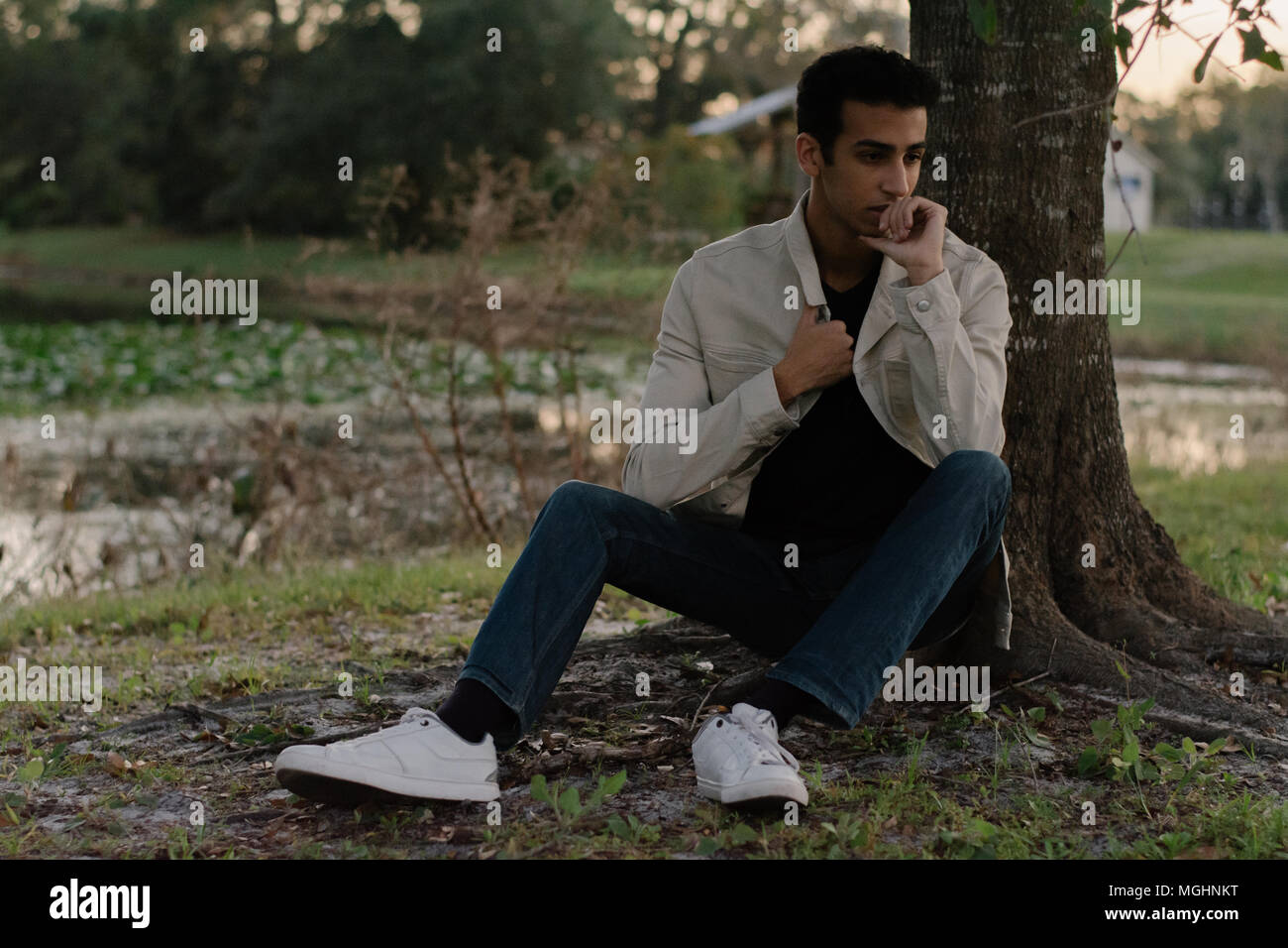 Junge moderne Trendy modische nahen östlichen Indischen männliches Modell Lachen und posiert in der Natur im Park für Portrait Kopf Schüsse Stockfoto