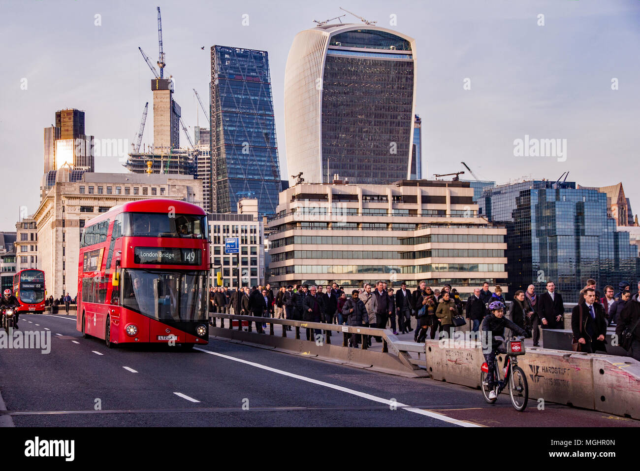 Stadt London, Großbritannien, 8. Februar 2018. Massen der Pendler im Berufsverkehr zu Fuß über London Bridge von der Stadt entfernt auf dem Weg nach Hause. Bus Mail-abruf Stockfoto