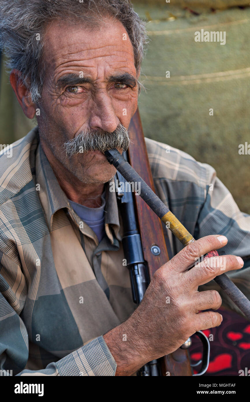 Iranischer Nomadenmensch, der zum Stamm Qashqai gehört und seine Pfeife raucht, in Firuzabad, Iran. Stockfoto