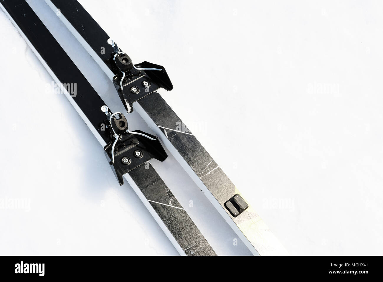 Paar neue Langlaufski auf einem weißen Winter schnee Hintergrund mit Kopie Raum für winterliche themed Sport und Ski Nordisch Designs Stockfoto