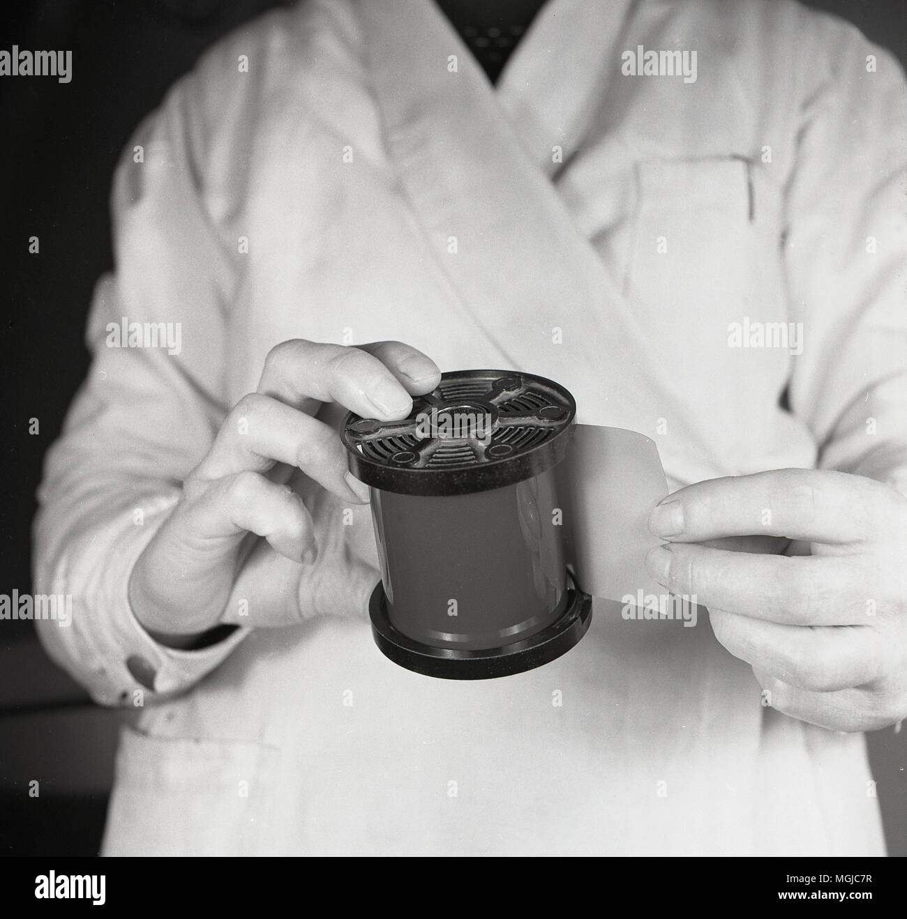 1950er Jahre, eine große Rolle von negativen Film durch einen Betreiber vor entwickelt werden. Stockfoto 1950er Jahre, eine große Rolle von negativen Film durch einen Betreiber vor entwickelt werden. Stockfoto