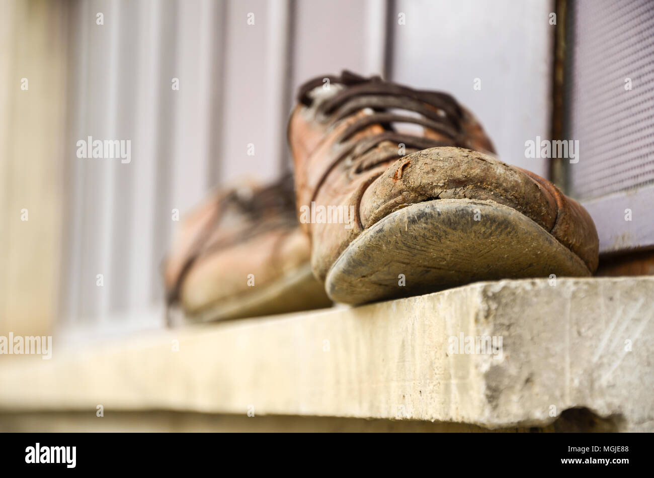Schlammig und alte Schuhe vor dem Fenster, Schuhe des Arbeiters, Arbeit, Wundsein, selektiven Fokus Stockfoto