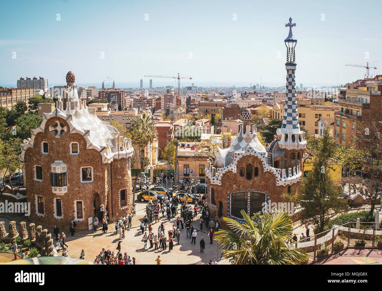 Fantasy Häuser von Gaudi am Eingang zum Parc Güell. Barcelona, Spanien. Besucher aus der ganzen Welt. Stadt Barcelona in der Ferne. Stockfoto