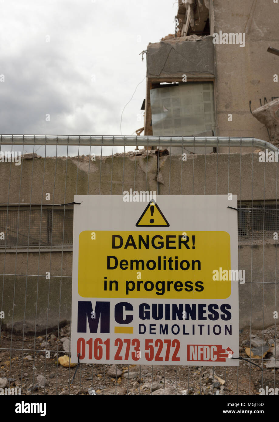 Gefahr Abriss in Arbeit Zeichen auf Sicherheitszaun vor Von teilweise abgerissenen Stahlbetonbauten in Bury lancashire uk Stockfoto