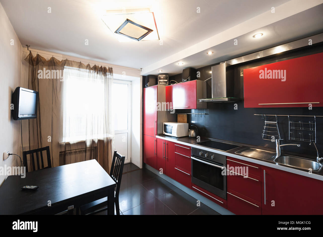 Moderne Küche Zimmer mit TV. Schwarz, Rot und Weiß design Stockfoto