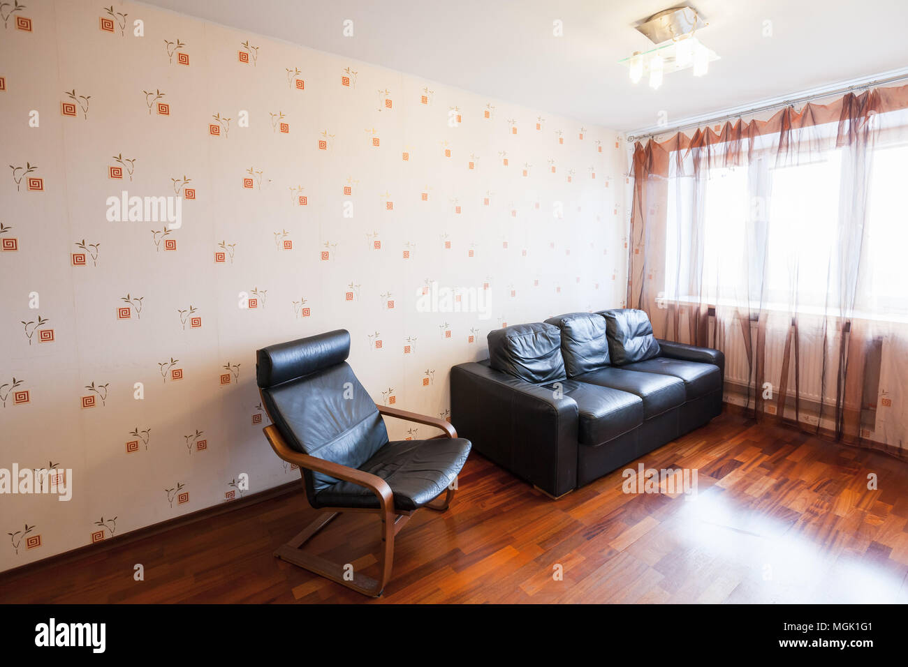Leeren Wohnzimmer Innenbereich mit schwarzem Leder Sessel und das Sofa in der Nähe von hellen Fenster Stockfoto