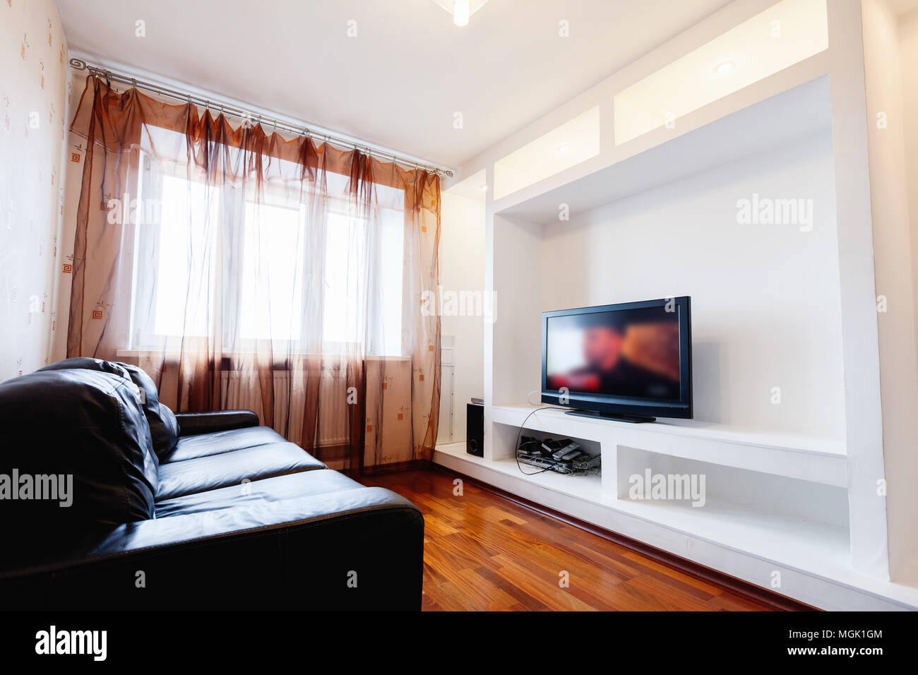 Leeren Wohnzimmer Innenbereich mit schwarzem Leder Sofa und Tv in Weiß installation Stockfoto