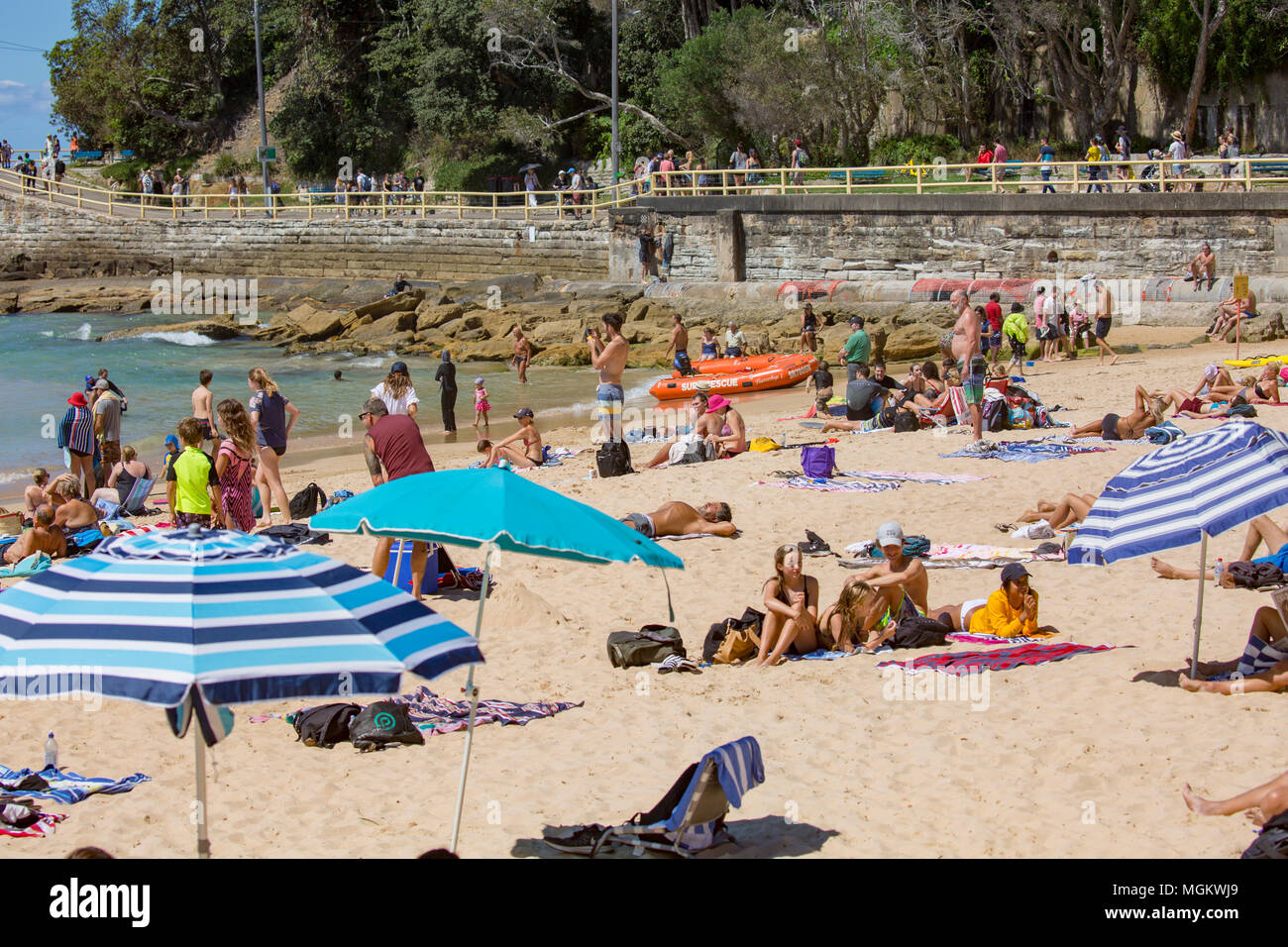 Menschen Liegewiese mit Sonnenschirmen auf Manly Beach in Sydney, Australien Stockfoto