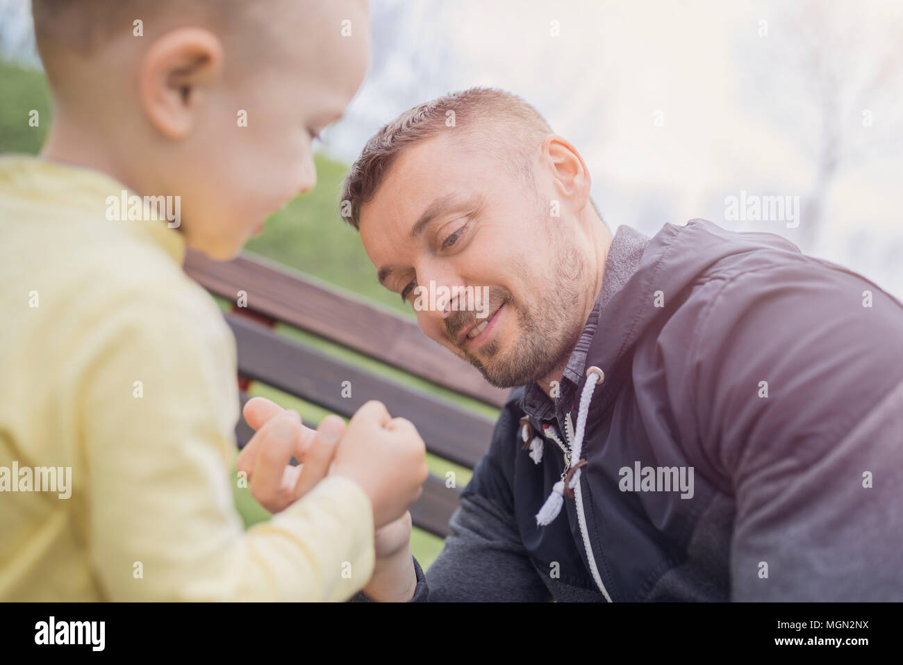 Closeup Portrait eines glücklichen Vater und Sohn spielen auf dem Spielplatz und Spaß zu haben. Junger Vater spielen mit seinem Baby draußen im Park. Vater und Sohn. Stockfoto