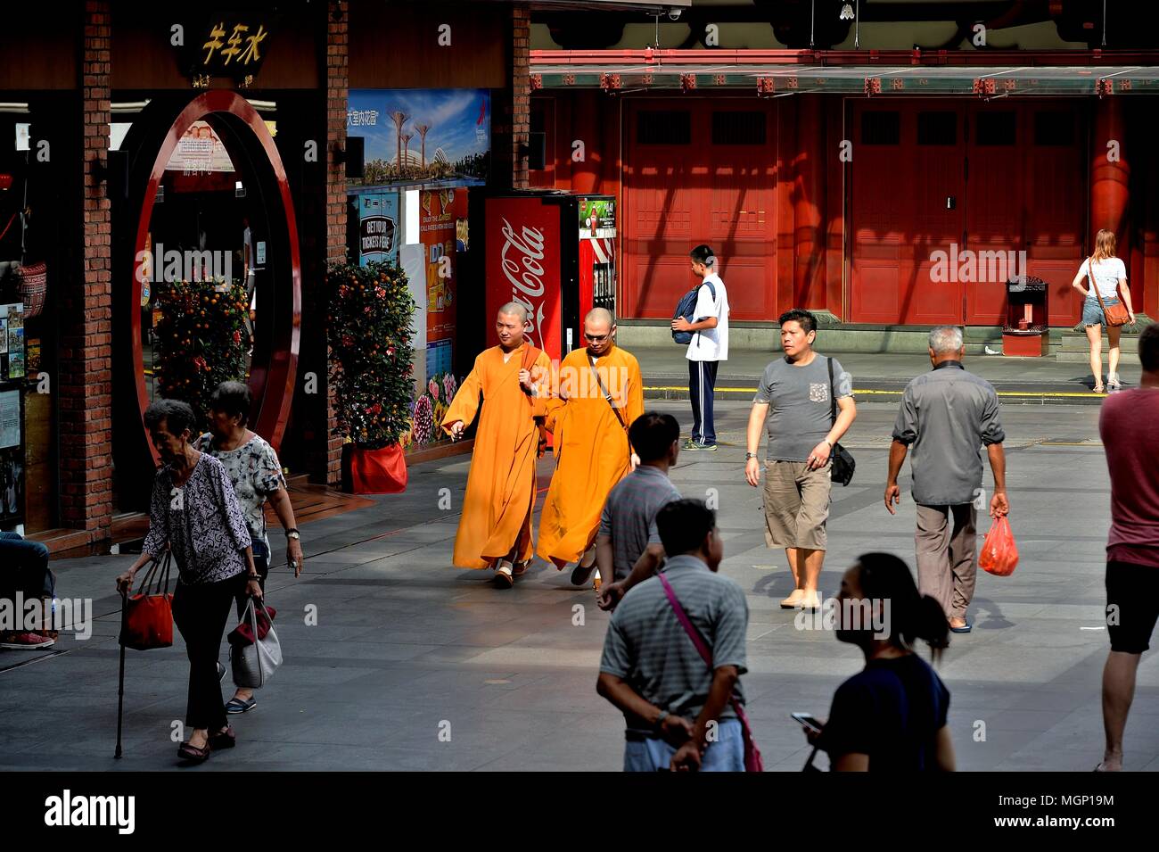 Zwei buddhistische Mönche in Safran Roben zu Fuß über den Platz außerhalb des Buddha Zahns Tempel in historischen Chinatown, Singapur Stockfoto