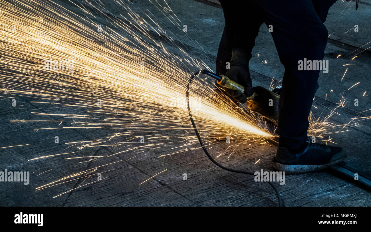 Mann schneidet Metall mit Winkelschleifer Stockfoto